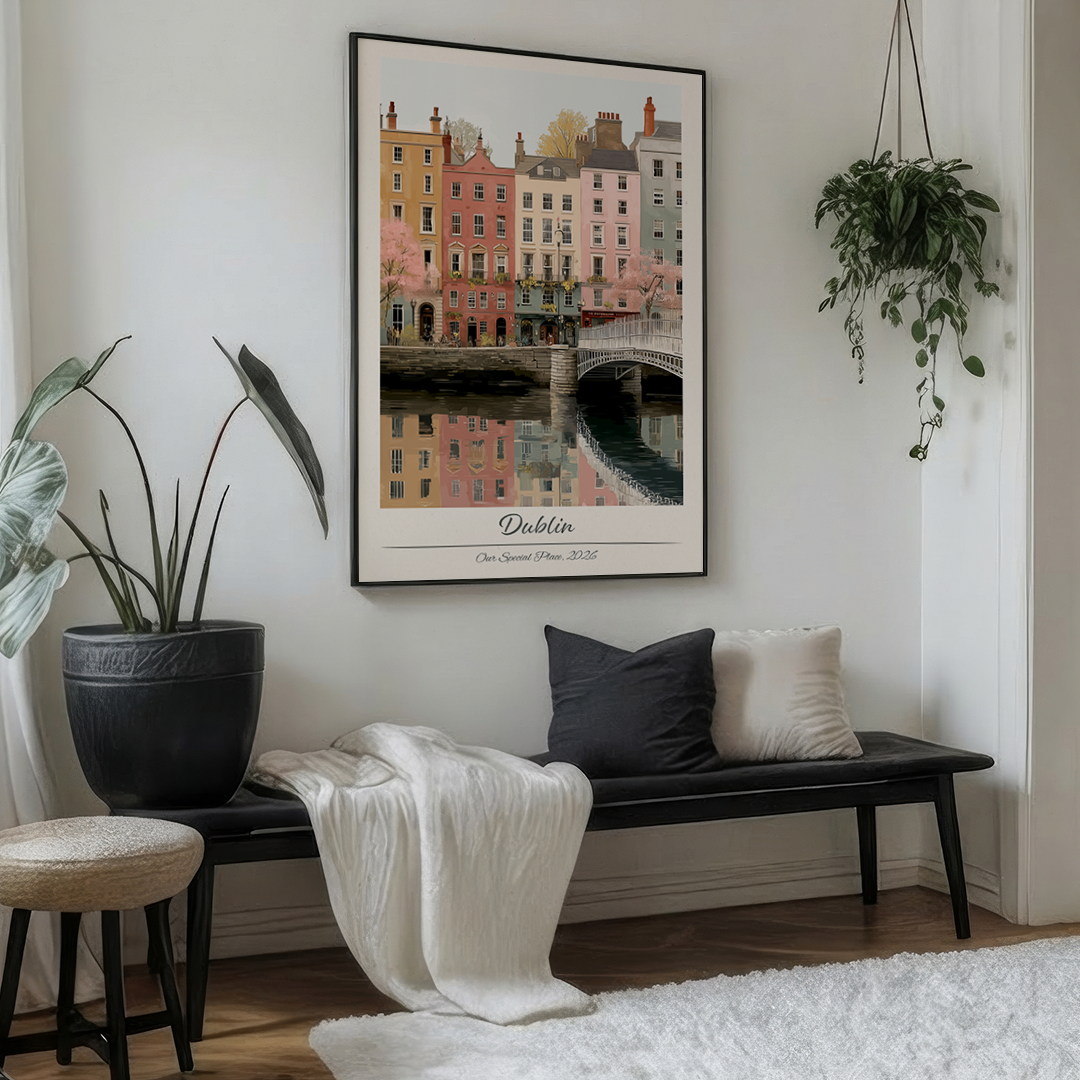 Framed artwork of a cityscape with buildings and a bridge, labeled 'Dublin', on a white brick wall.