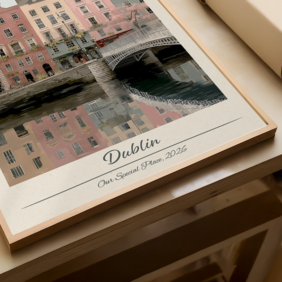 Framed artwork of a cityscape with buildings and a bridge, labeled 'Dublin', on a white brick wall.