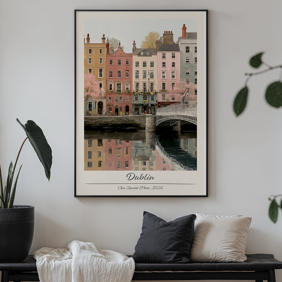 Framed artwork of a cityscape with buildings and a bridge, labeled 'Dublin', on a white brick wall.