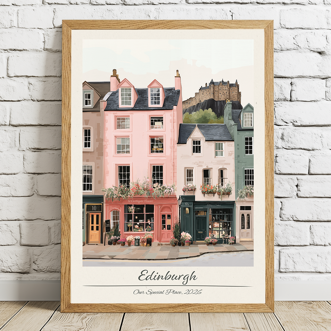 Framed artwork of Edinburgh street scene with a castle in the background on a white brick wall.