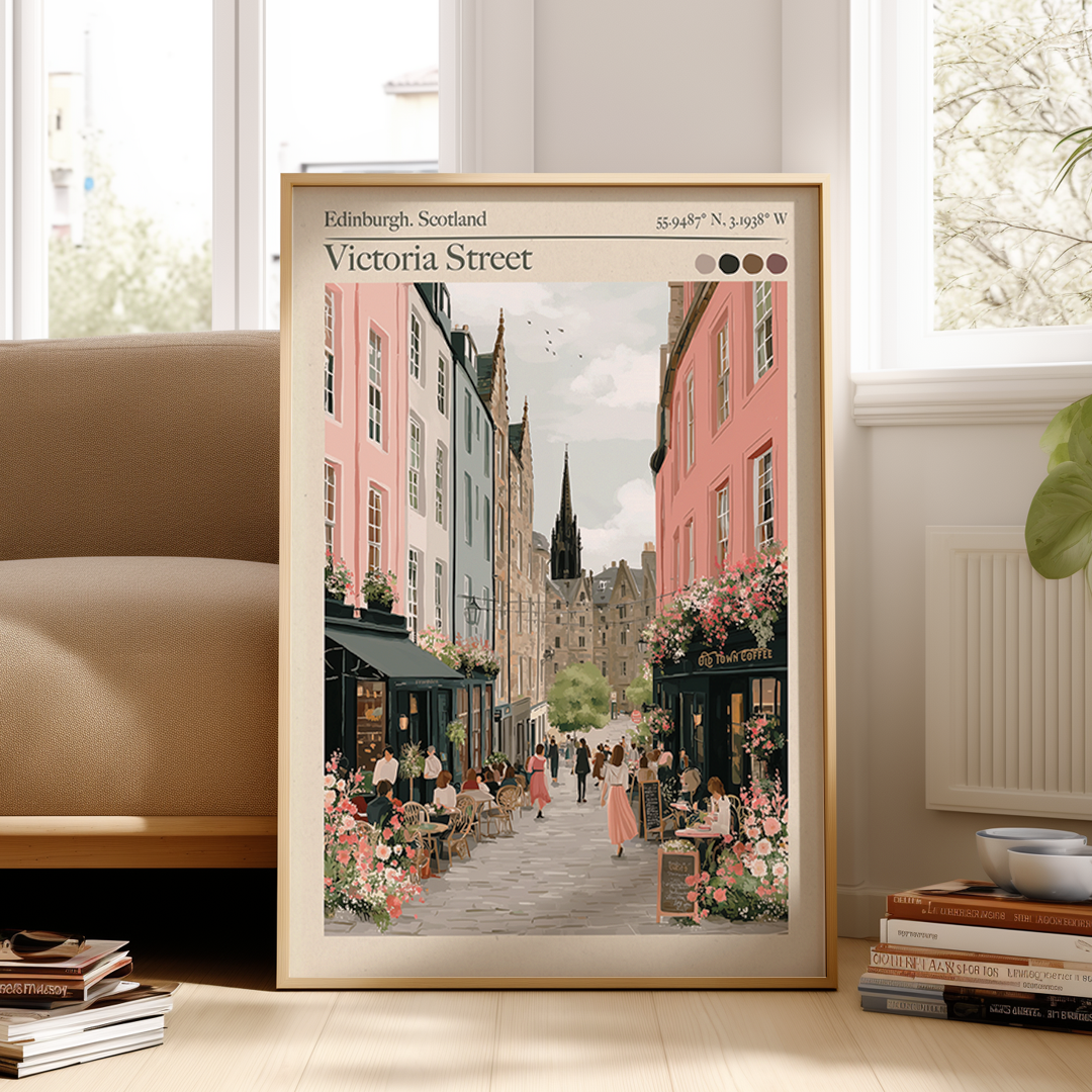 Framed print of Victoria Street, Edinburgh, Scotland on a wall in a room with a couch and books.
