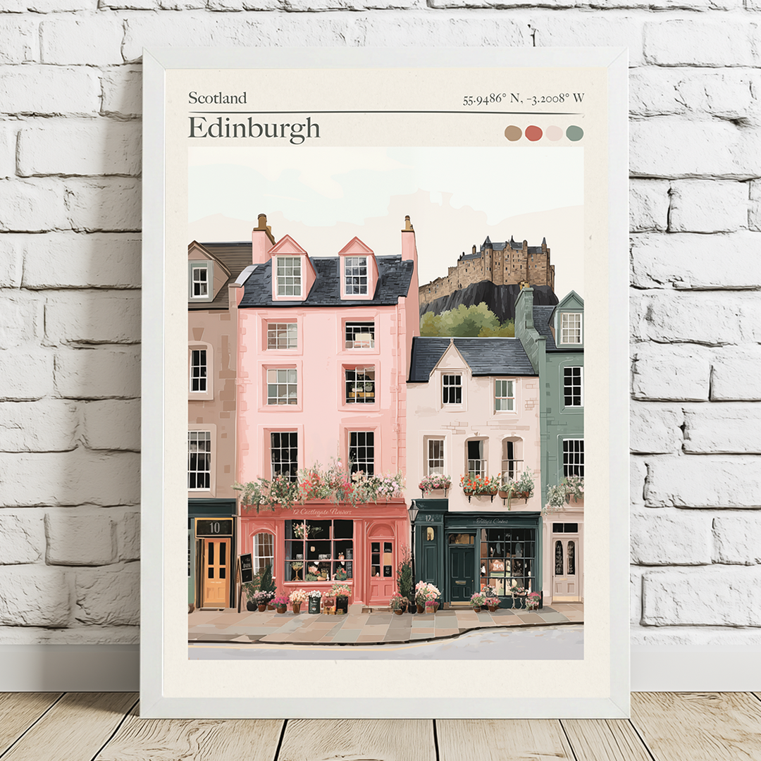 Framed artwork of Edinburgh street scene with colorful buildings and castle on a white brick wall.