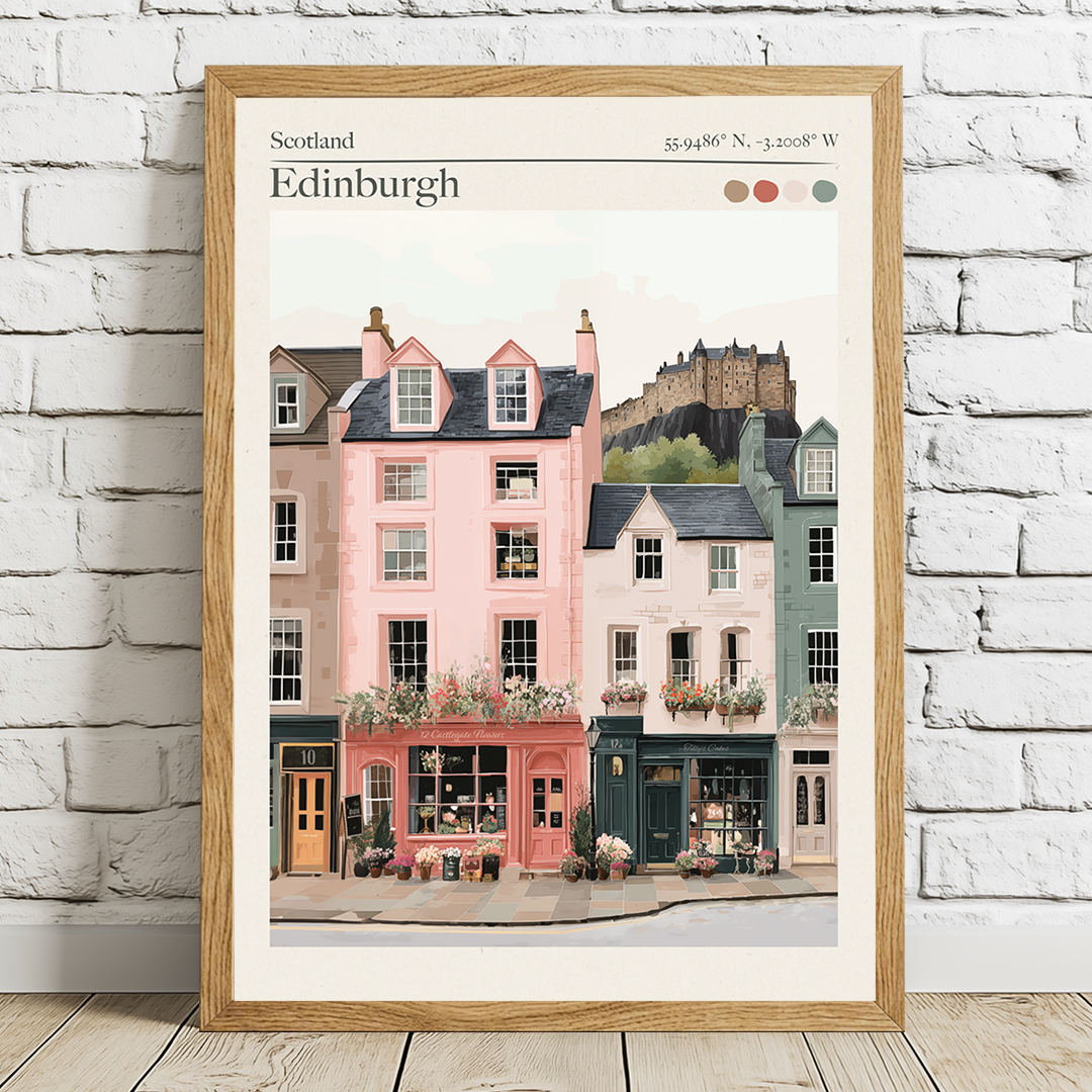 Framed artwork of Edinburgh street scene with buildings and castle on a white brick wall.