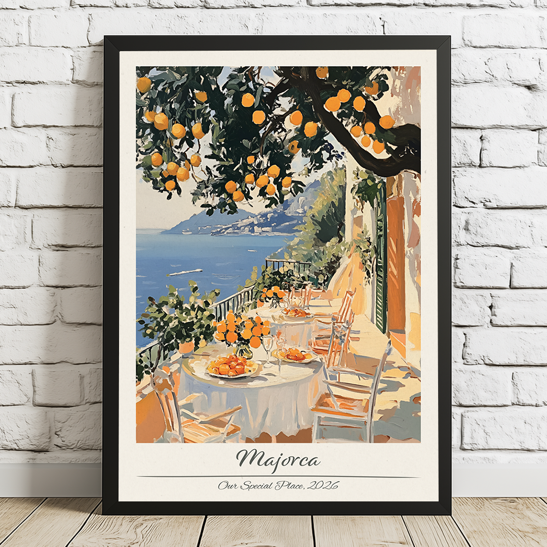 Framed artwork of a scenic view with tables, chairs, and an orange tree on a white brick wall.