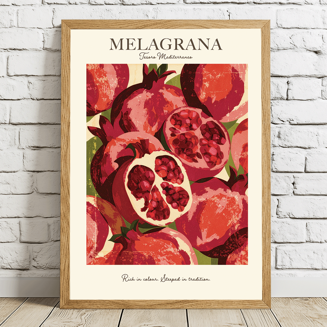 A framed art print featuring a stylized illustration of red pomegranates with the text 'MELAGRANA' at the top, leaning against a white brick wall on a light wood floor.