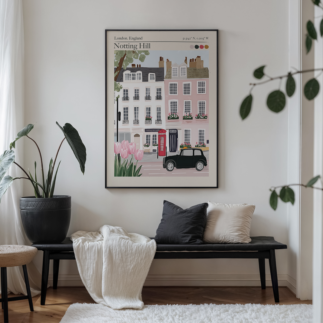 Framed artwork of a street scene in Notting Hill, London, above a bench with cushions.