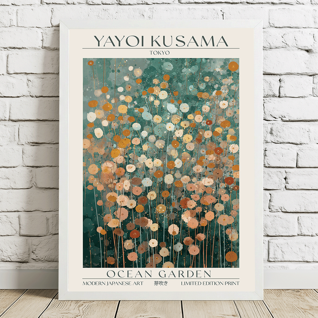 A framed art print featuring Yayoi Kusama's 'Ocean Garden' poster, leaning against a white brick wall on a light wooden floor. The poster has a cream border with black text and a central abstract floral design in teal, orange, and cream.