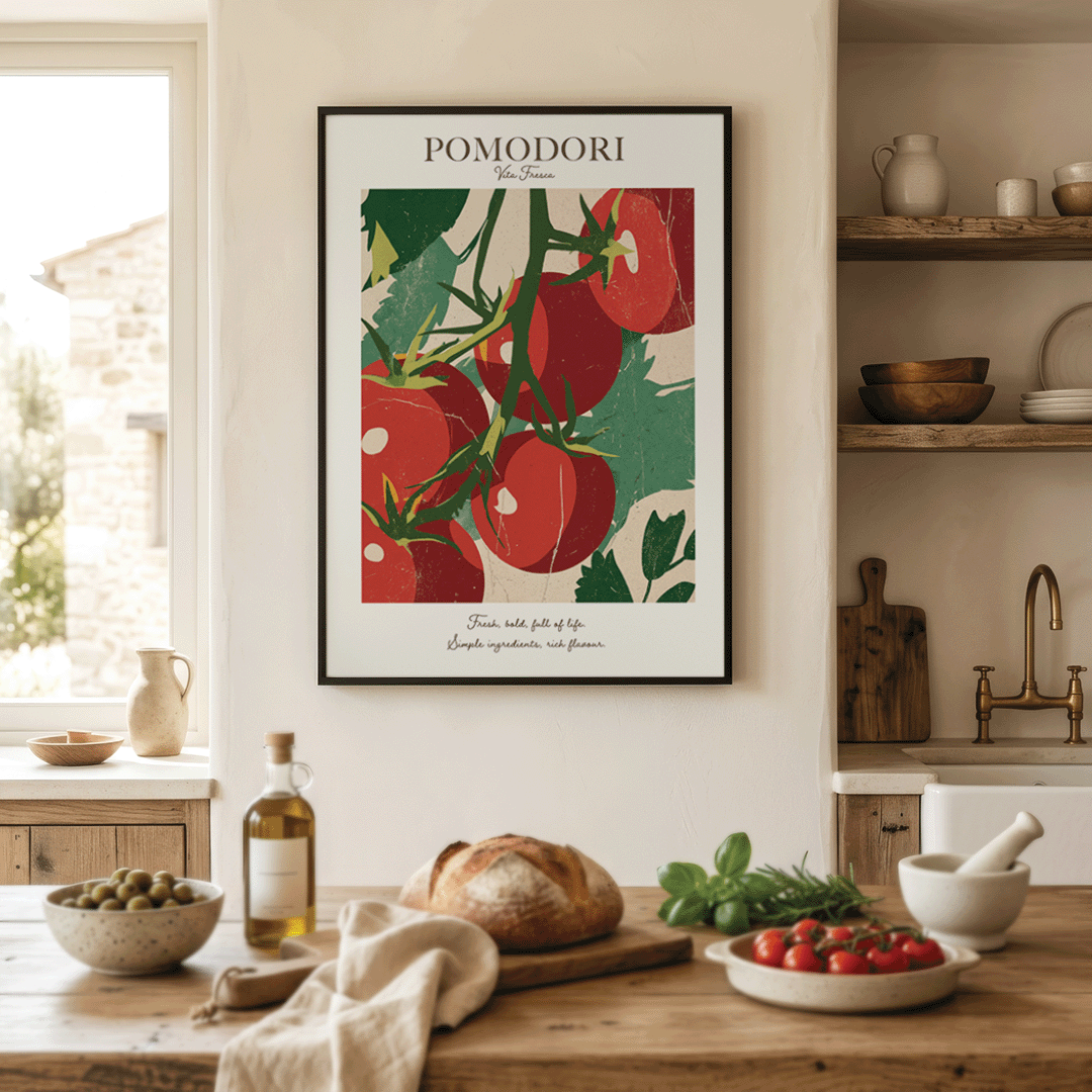 A framed art print featuring a retro-style illustration of red tomatoes on a vine with the text 'POMODORI' at the top, displayed on a kitchen wall above a wooden table with food props.