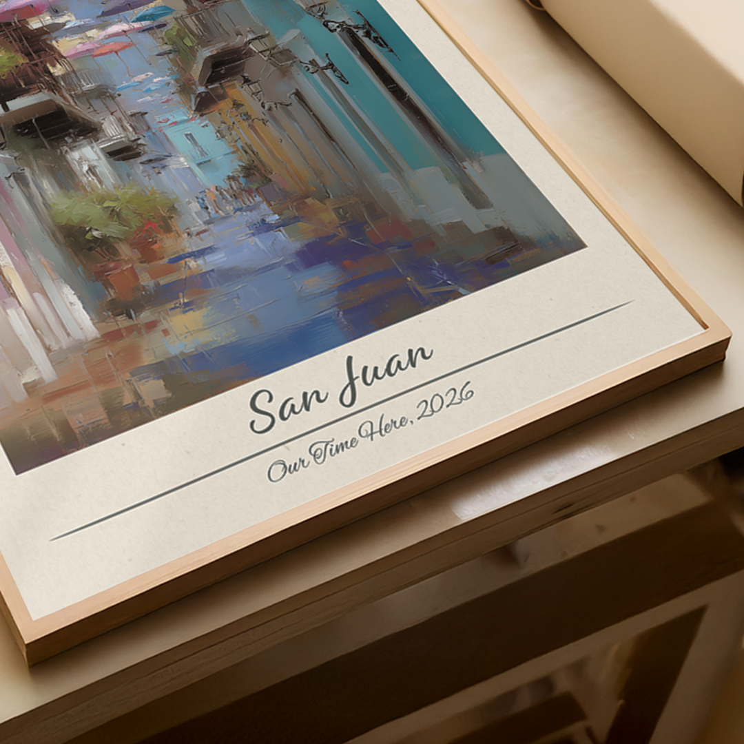 Framed artwork of a colorful scene with 'San Juan' and 'Our Time Here, 2026' text.