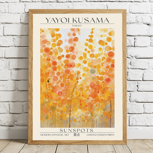 Framed Yayoi Kusama art print titled 'Sunspots' on a white brick wall.