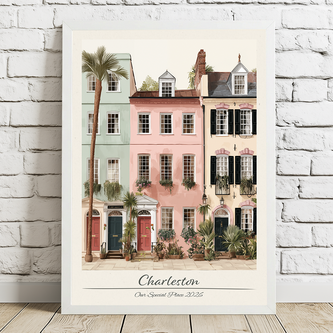 Framed artwork of colorful houses and palm trees with 'Charleston' text on a white brick wall.