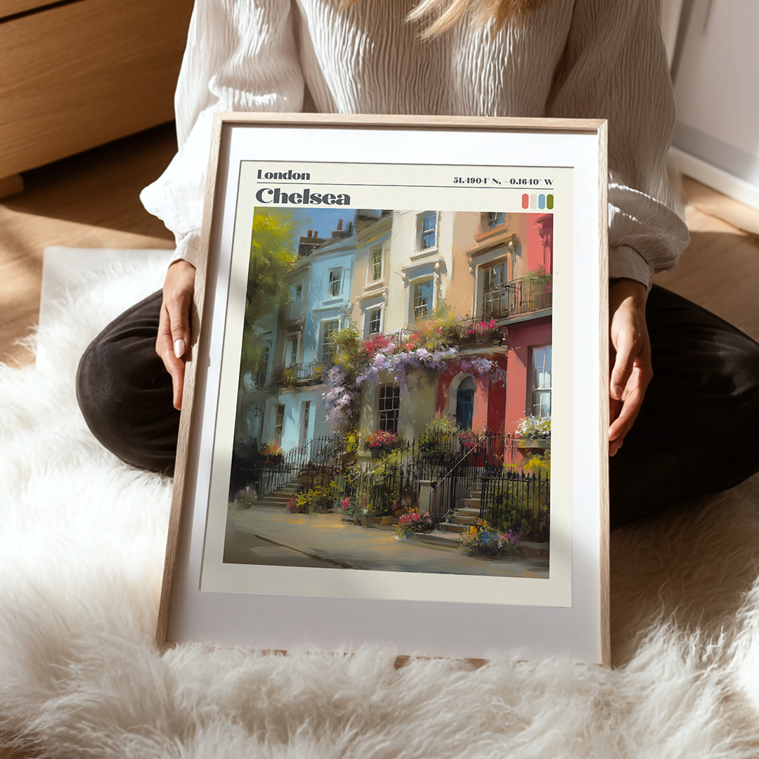 Person holding a framed print of London Chelsea with a scenic view of colorful houses.