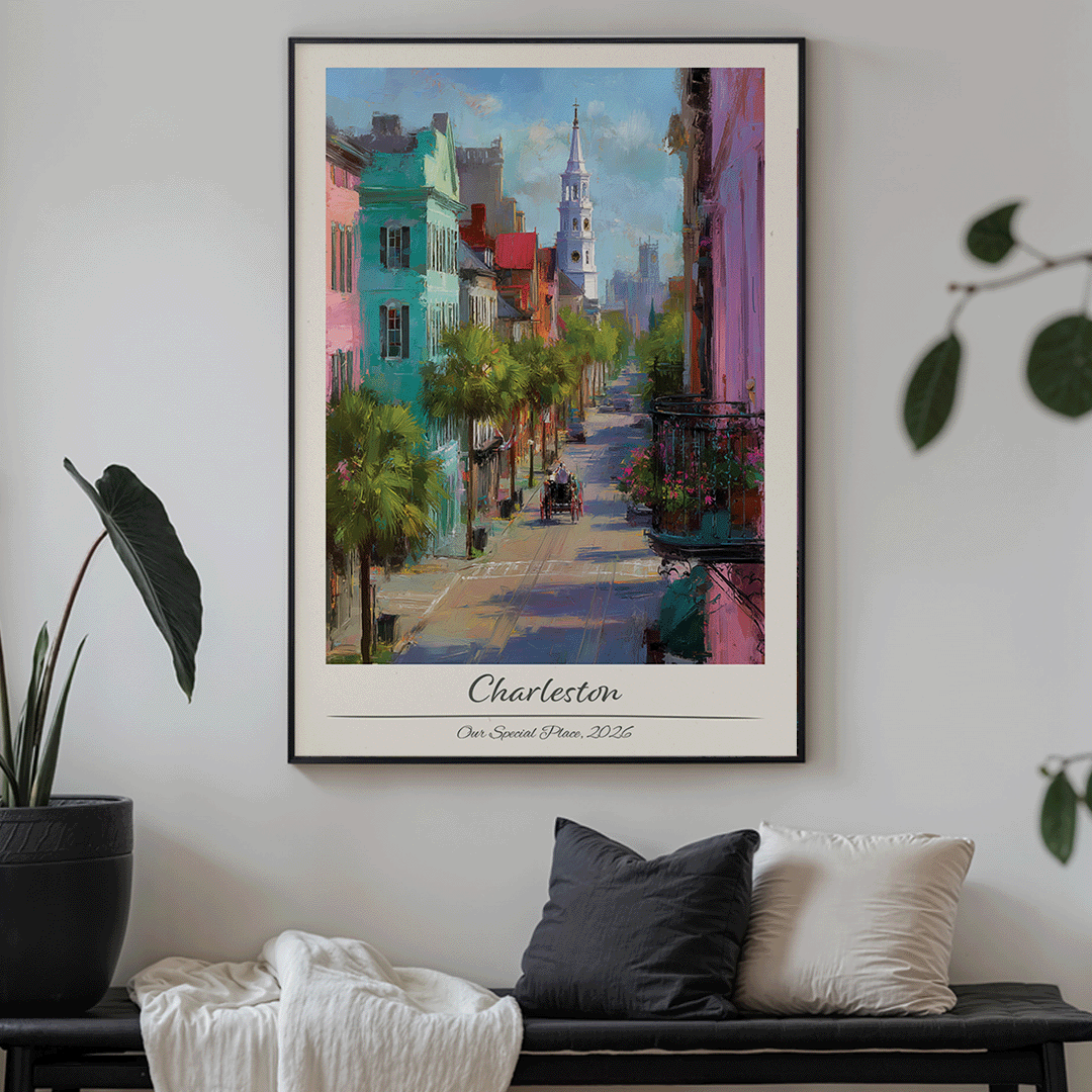 Framed artwork of a colorful street scene in Charleston on a wall above a sofa.
