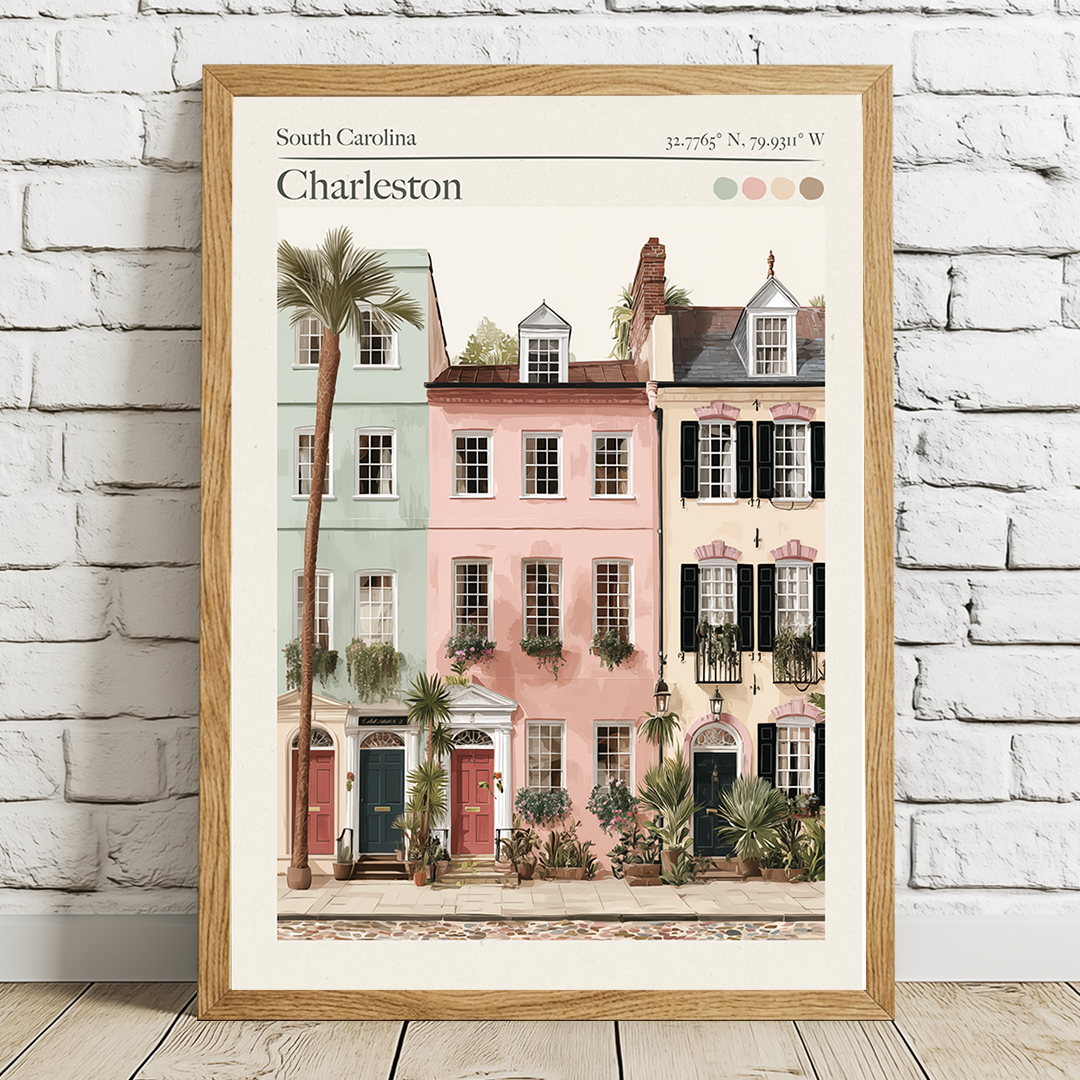 Framed artwork of Charleston with colorful houses and palm trees on a white brick wall.
