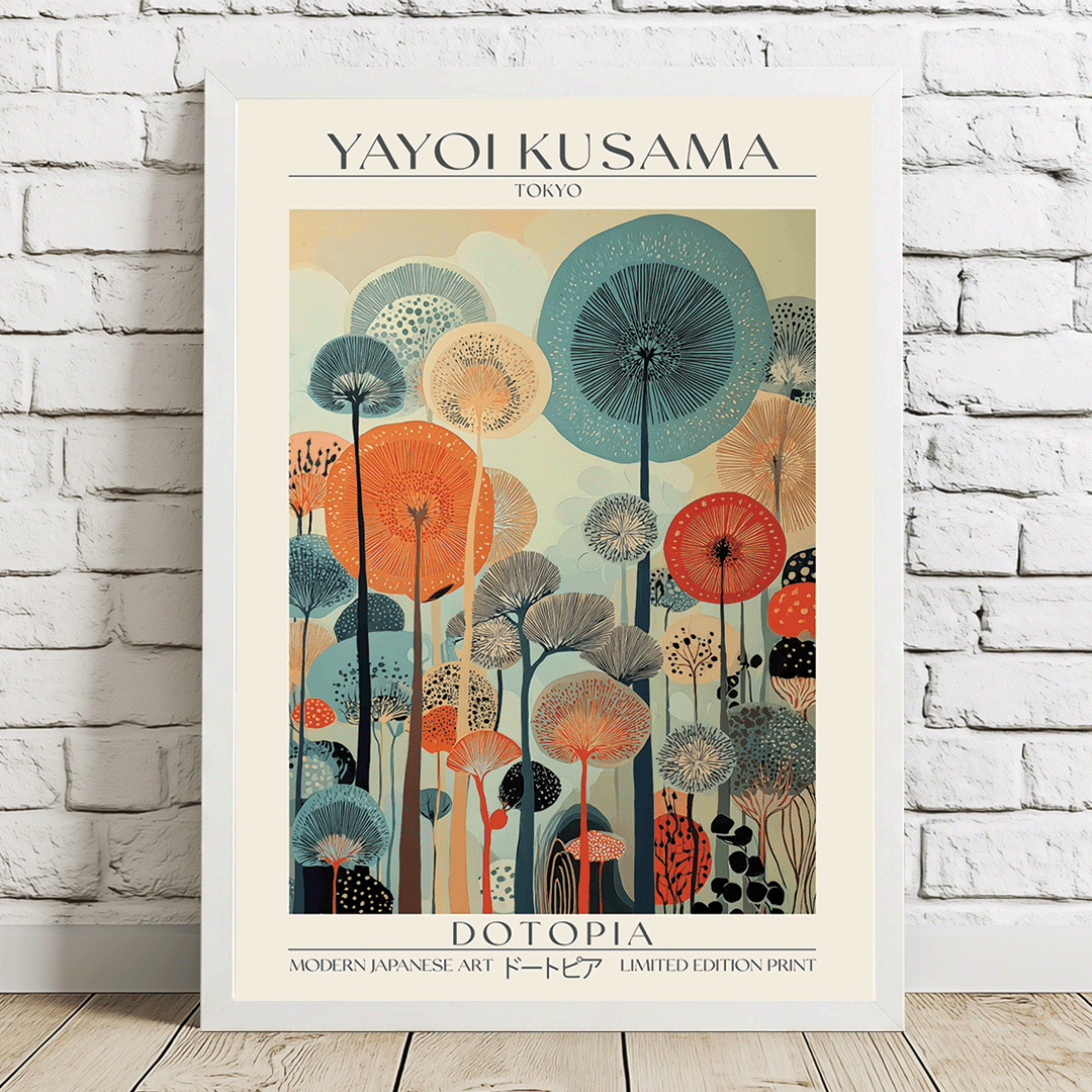 A framed art print featuring a stylized Japanese illustration with the text 'YAYOI KUSAMA' at the top and 'DOTOPIA' at the bottom, leaning against a white brick wall on a light wood floor.
