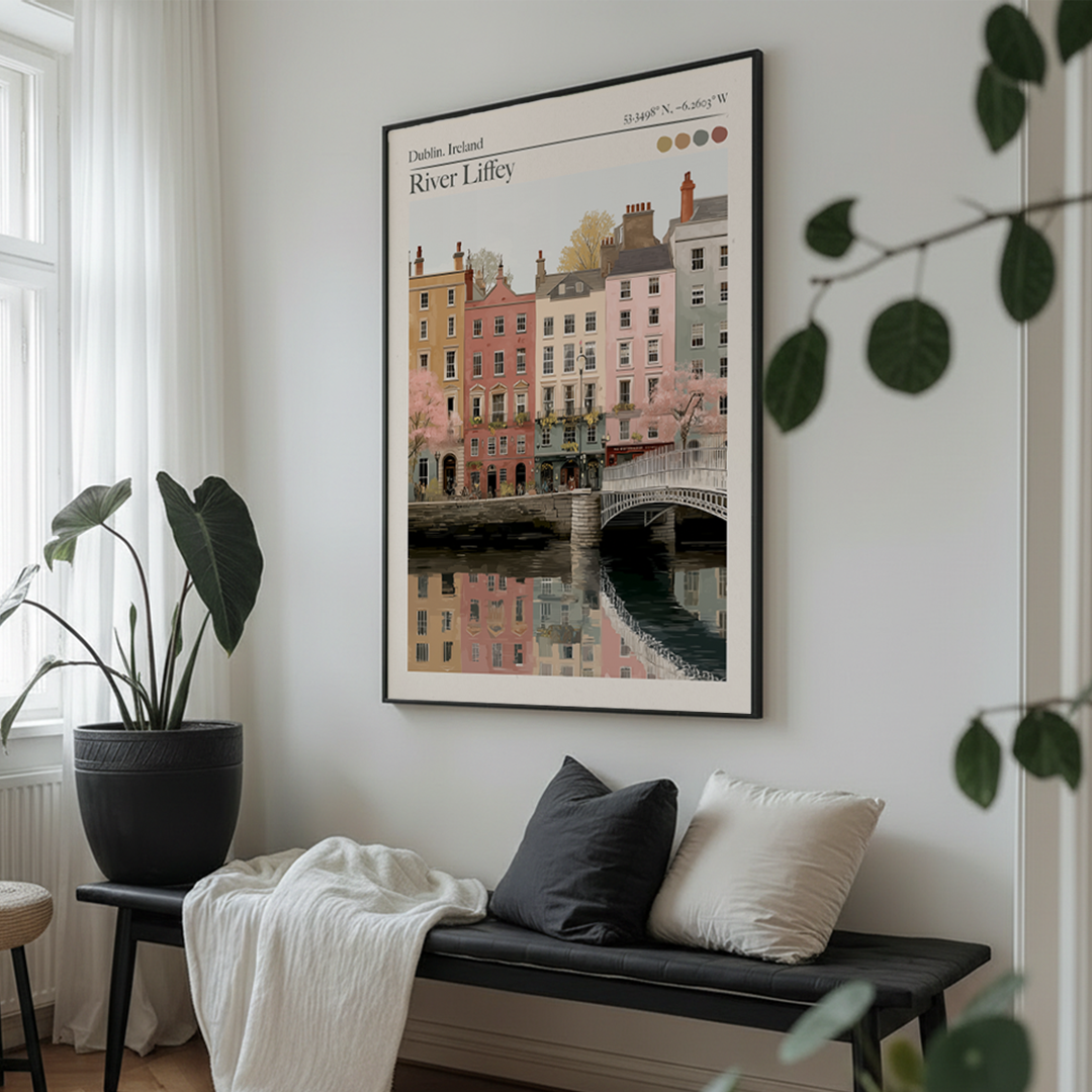 Framed artwork of a cityscape over a river on a wall above a bench with cushions.