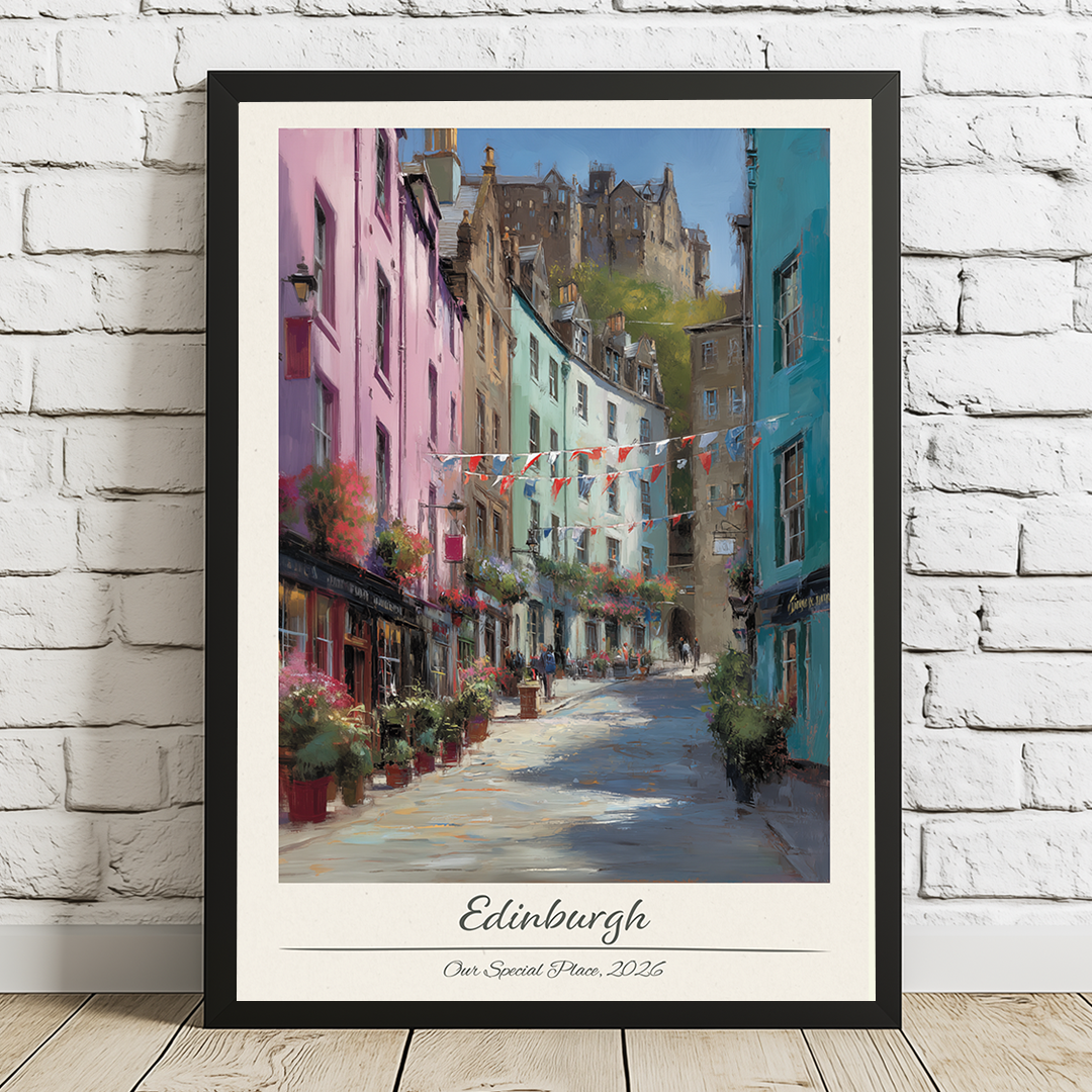 Framed artwork of a colorful street scene in Edinburgh on a white brick wall.