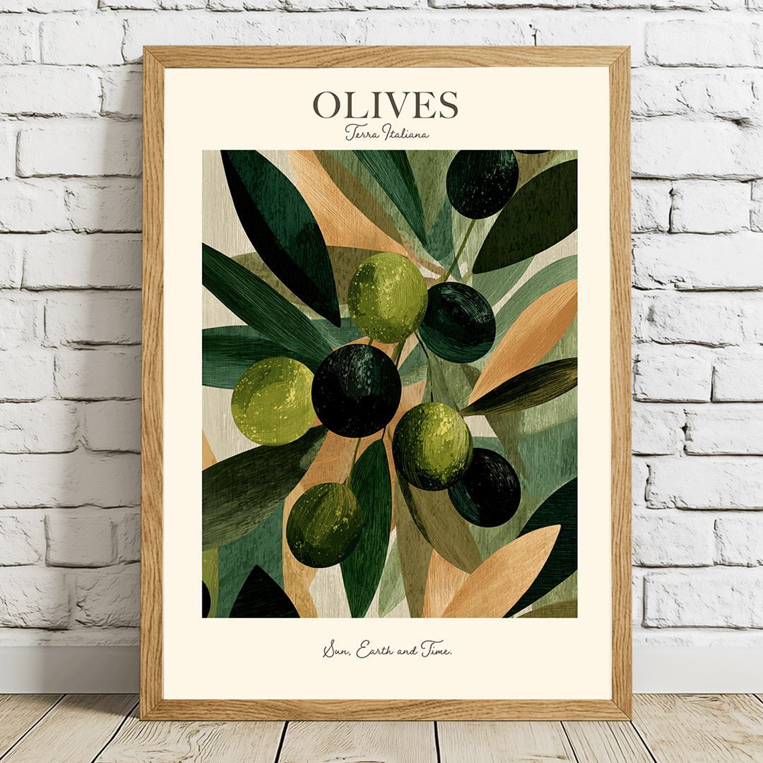 A framed art print featuring an illustration of green and black olives on leaves, titled 'OLIVES' with 'Gourmand Nature' written below, leaning against a white brick wall on a light wood floor.
